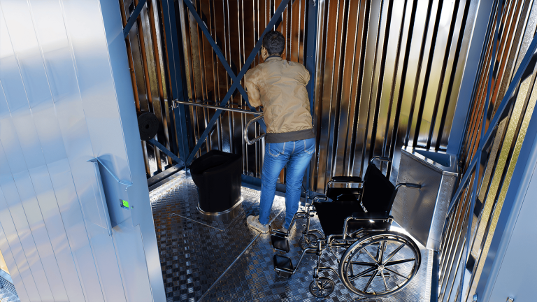 Un monsieur en chaise roulante dans la toilette écologique NIX-01